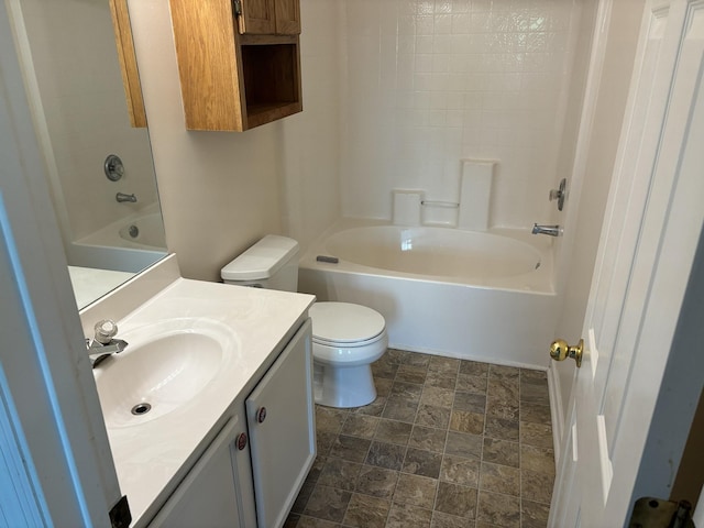 bathroom with vanity, bathtub / shower combination, stone finish floor, and toilet