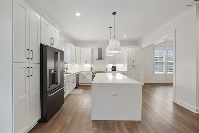 kitchen with dishwasher, wall chimney exhaust hood, high end refrigerator, decorative backsplash, and a kitchen island