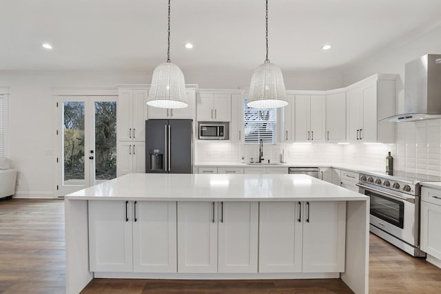 kitchen featuring a sink, stainless steel appliances, recessed lighting, and wall chimney exhaust hood