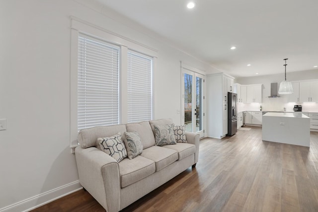 living room with recessed lighting, baseboards, and wood finished floors