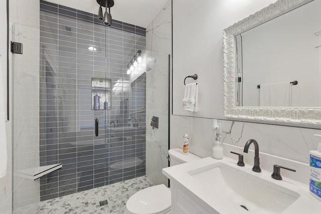 bathroom with vanity, toilet, tile walls, tasteful backsplash, and a shower stall