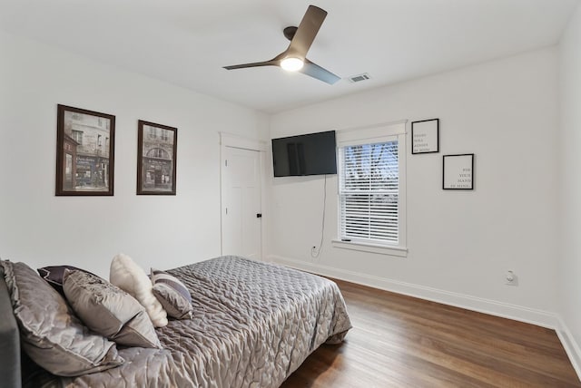 bedroom with dark wood-style flooring, baseboards, visible vents, and a ceiling fan