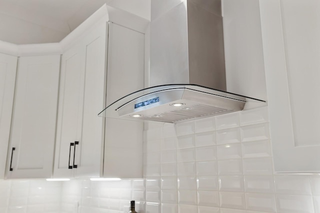 interior details featuring wall chimney exhaust hood and white cabinetry
