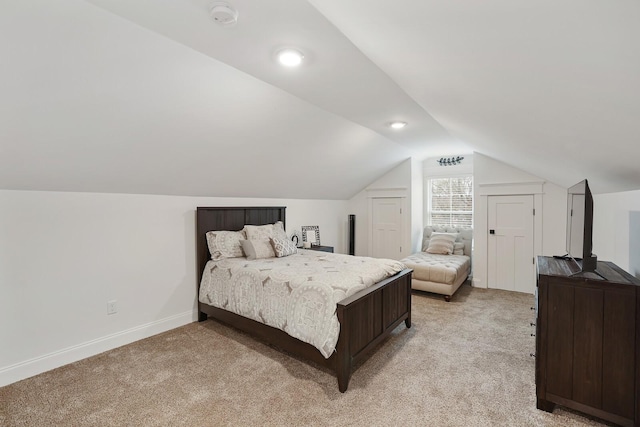 bedroom with baseboards, vaulted ceiling, and light colored carpet