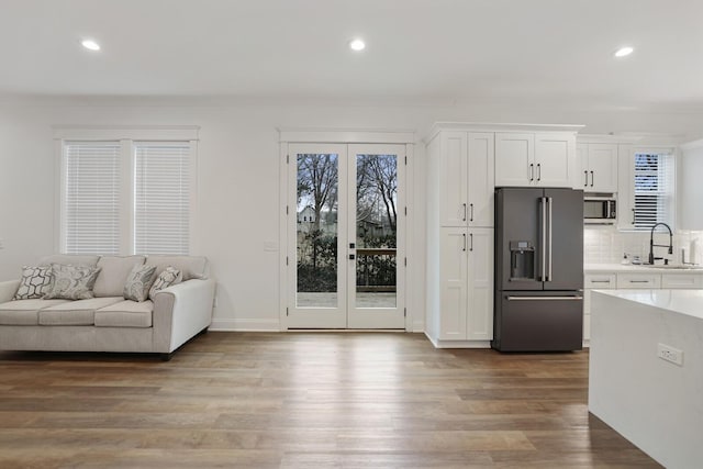 interior space with white cabinets, light wood finished floors, french doors, stainless steel microwave, and high quality fridge