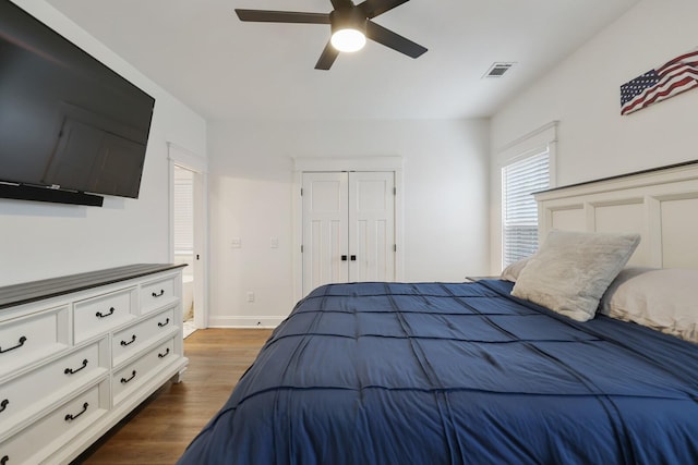 bedroom featuring a ceiling fan, visible vents, baseboards, a closet, and dark wood-style floors