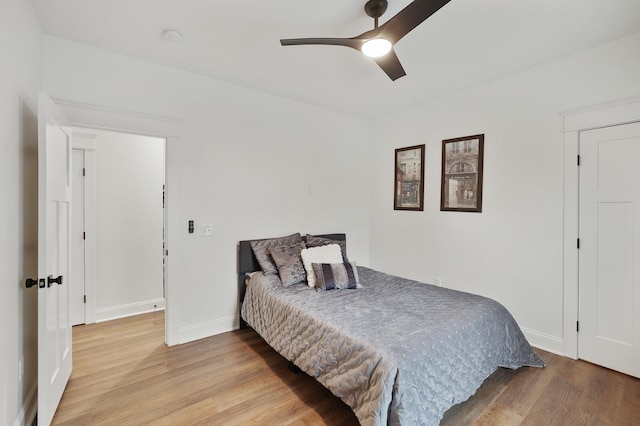 bedroom with baseboards, a ceiling fan, and wood finished floors