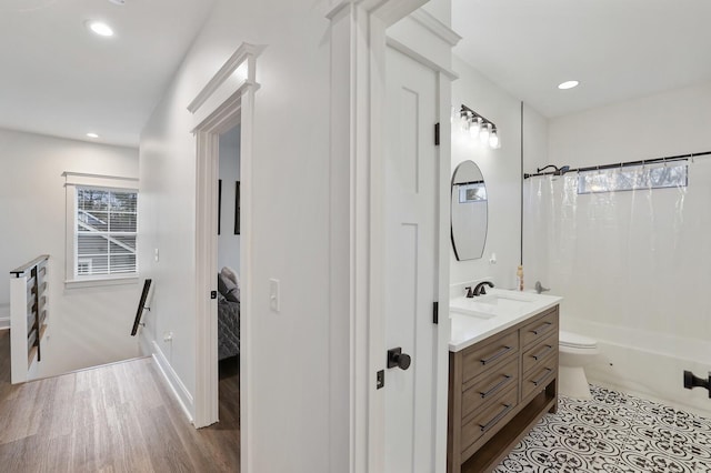 full bathroom with wood finished floors, shower / tub combo, vanity, toilet, and recessed lighting