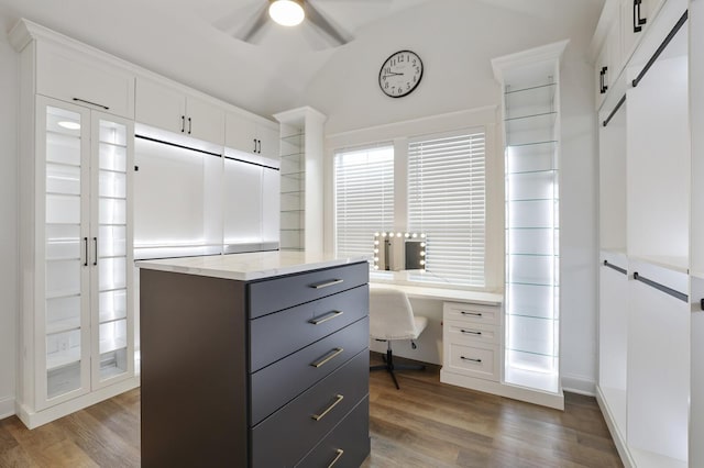 walk in closet featuring built in study area, ceiling fan, and wood finished floors