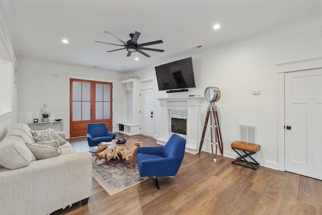 living room with visible vents, wood finished floors, recessed lighting, a fireplace with raised hearth, and a ceiling fan