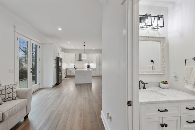 interior space with recessed lighting, a sink, baseboards, and wood finished floors
