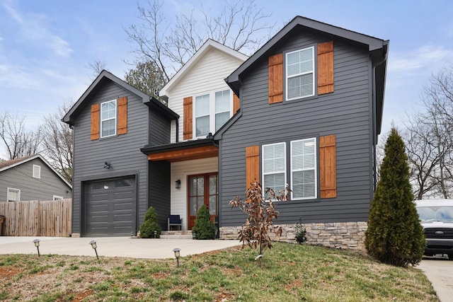 view of front of home with fence, driveway, and a garage
