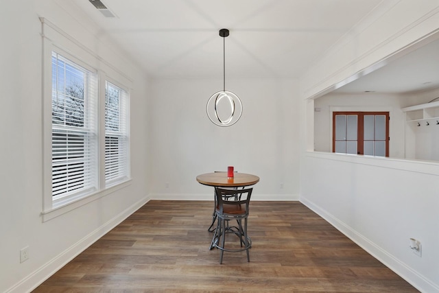 unfurnished dining area featuring baseboards, visible vents, and wood finished floors