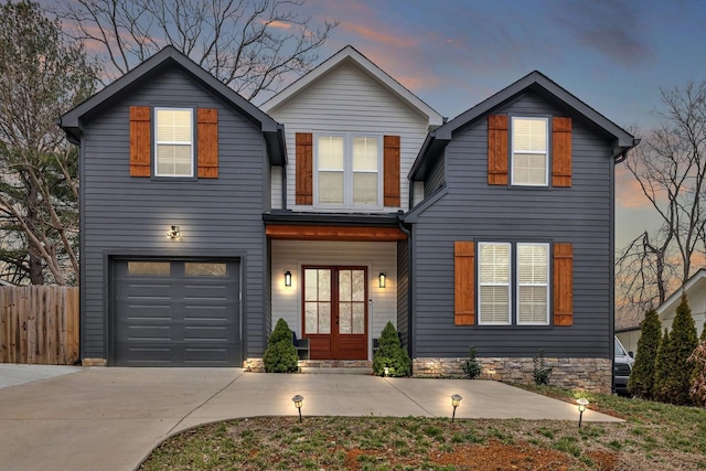 view of front facade featuring a garage, fence, and driveway