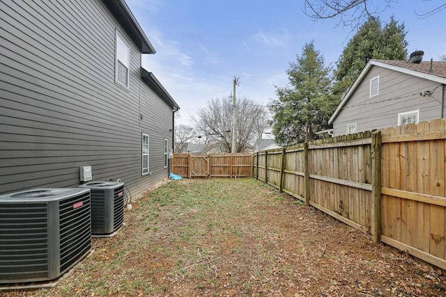 view of yard with a fenced backyard and central AC