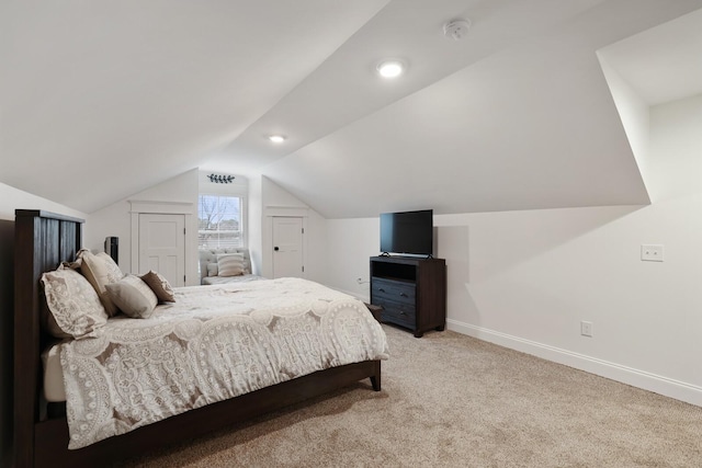 bedroom with baseboards, light carpet, and lofted ceiling