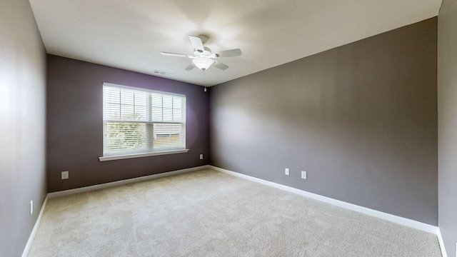 spare room featuring baseboards, a ceiling fan, carpet flooring, and visible vents