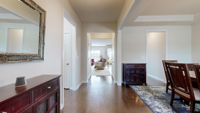 hallway with baseboards, dark wood-style flooring, and crown molding