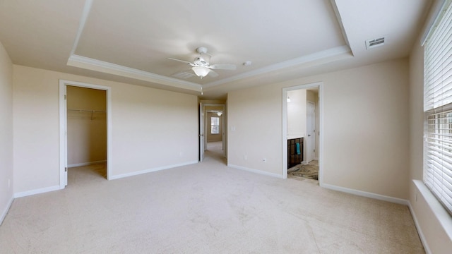 unfurnished bedroom with visible vents, a raised ceiling, and multiple windows