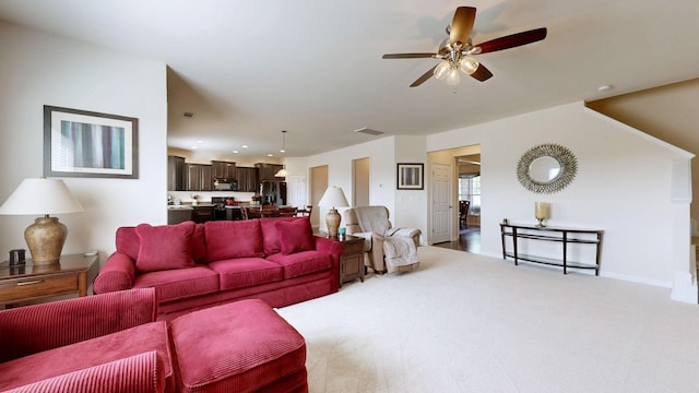 living room featuring visible vents, a ceiling fan, baseboards, and light carpet
