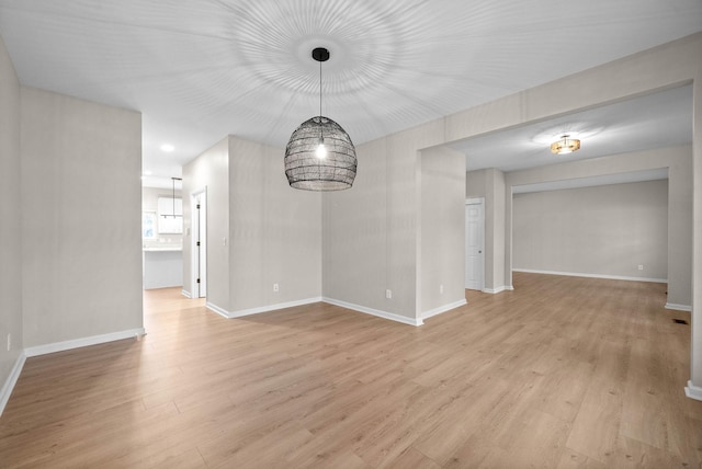 unfurnished dining area with baseboards and light wood-type flooring