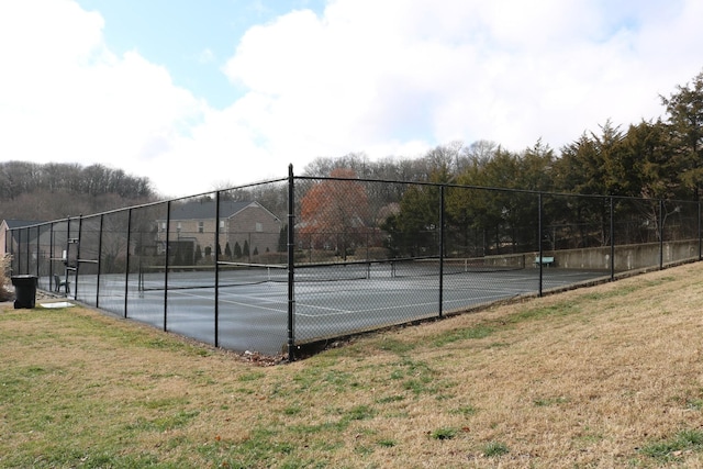 view of sport court featuring a yard and fence