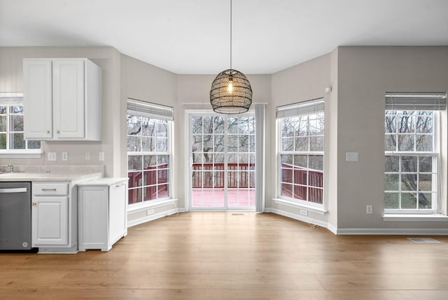unfurnished dining area featuring a healthy amount of sunlight and light wood finished floors