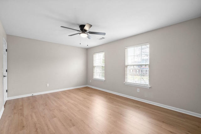 unfurnished room featuring baseboards, a ceiling fan, light wood finished floors, and visible vents