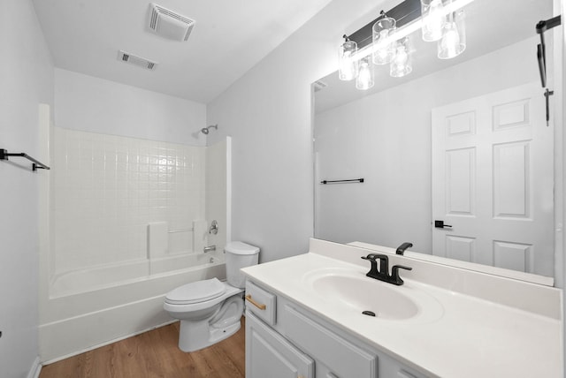 bathroom with toilet, visible vents, wood finished floors, and vanity