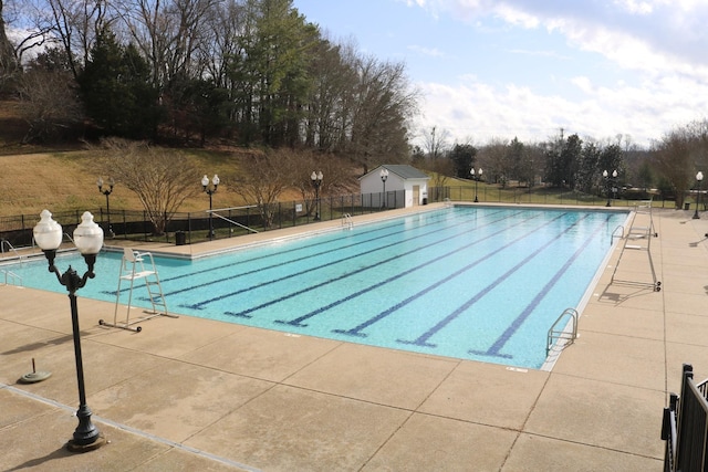 pool featuring fence and a patio area