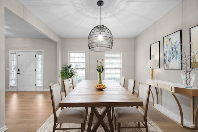 dining area with baseboards and light wood-type flooring