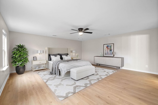 bedroom featuring a ceiling fan, baseboards, and wood finished floors