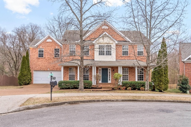view of front facade with an attached garage, driveway, brick siding, and covered porch