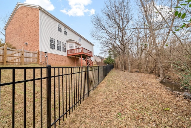 view of yard featuring a fenced backyard, a wooden deck, and stairway