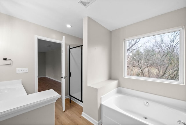 bathroom with baseboards, a shower stall, wood finished floors, visible vents, and a bath