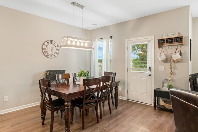 dining area featuring baseboards and light wood-style flooring