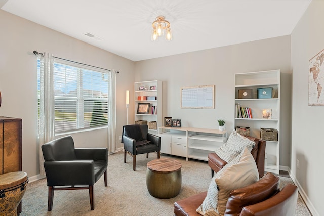 sitting room with light colored carpet, visible vents, baseboards, and a notable chandelier