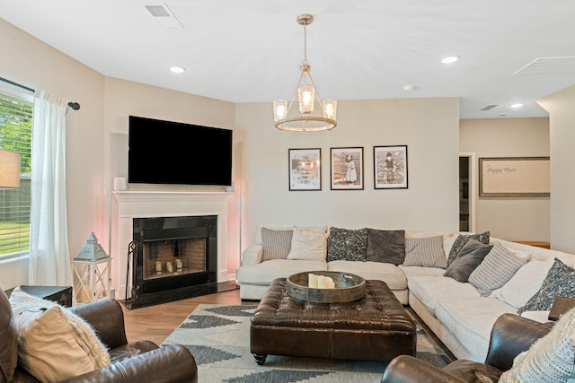 living room with a fireplace, visible vents, and wood finished floors