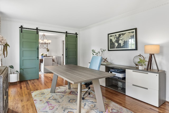 office featuring ornamental molding, a barn door, and wood finished floors