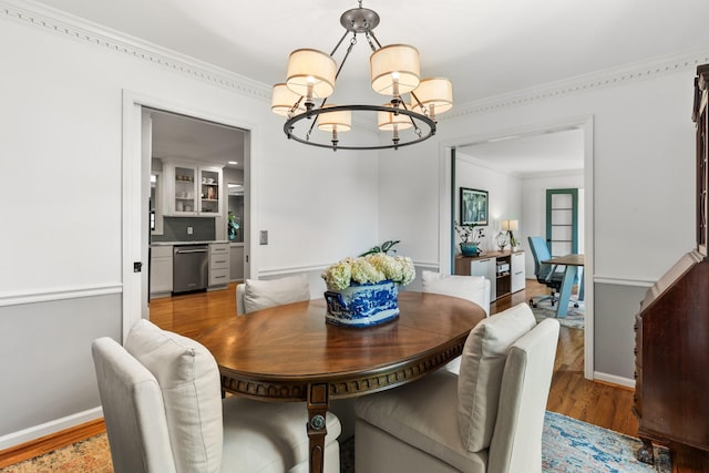 dining area with baseboards, a chandelier, ornamental molding, and wood finished floors