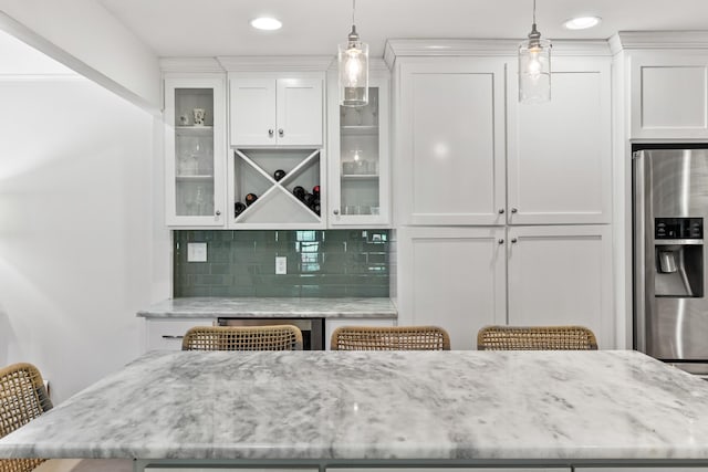 bar featuring stainless steel fridge with ice dispenser, a dry bar, backsplash, and decorative light fixtures