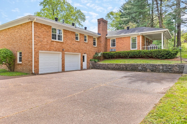 exterior space featuring concrete driveway, brick siding, a chimney, and a garage