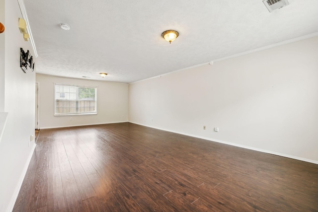 unfurnished room featuring crown molding, dark wood-style flooring, a textured ceiling, baseboards, and visible vents
