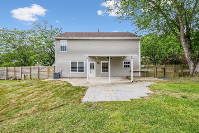 back of property with central air condition unit, a yard, a fenced backyard, and a patio area