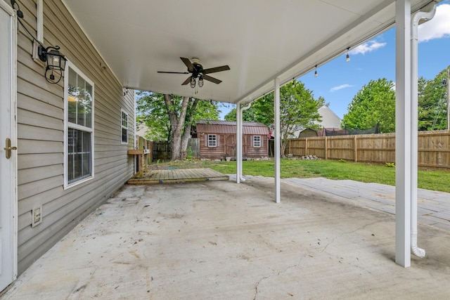 view of patio featuring an outdoor structure, a ceiling fan, and a fenced backyard