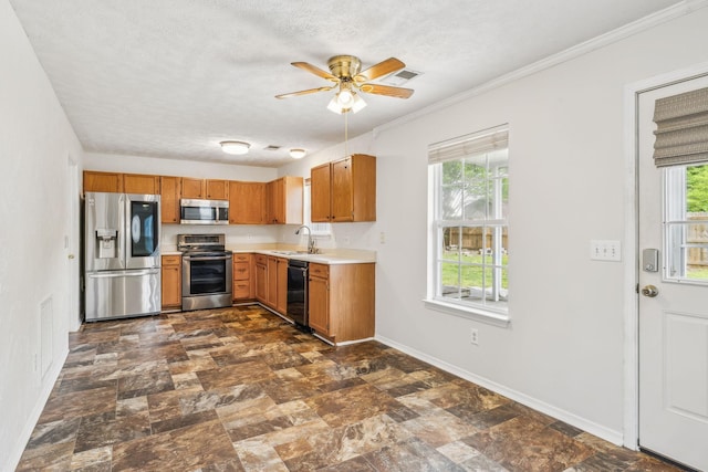 kitchen with a ceiling fan, light countertops, baseboards, a sink, and stainless steel appliances