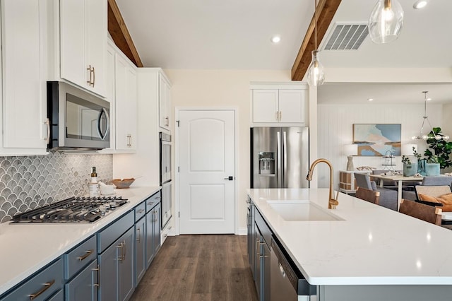 kitchen with dark wood-style flooring, visible vents, beam ceiling, a sink, and stainless steel appliances