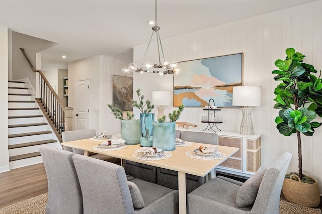 dining space with an inviting chandelier, recessed lighting, stairs, and wood finished floors