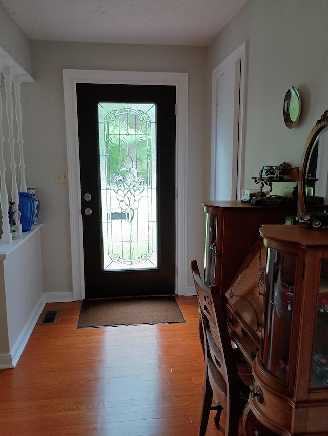 foyer featuring light wood finished floors and visible vents