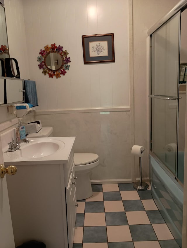 bathroom with vanity, shower / bath combination with glass door, tile patterned floors, and toilet